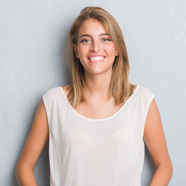 woman leaning against wall smiling