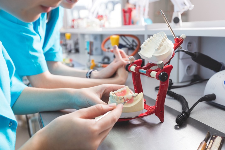 Dental technician working on a set of artificial teeth in a lab in Santa Barbara, CA.
