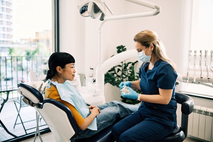 Dentist showing a dental model to a patient seated in a treatment chair in Santa Barbara, CA.